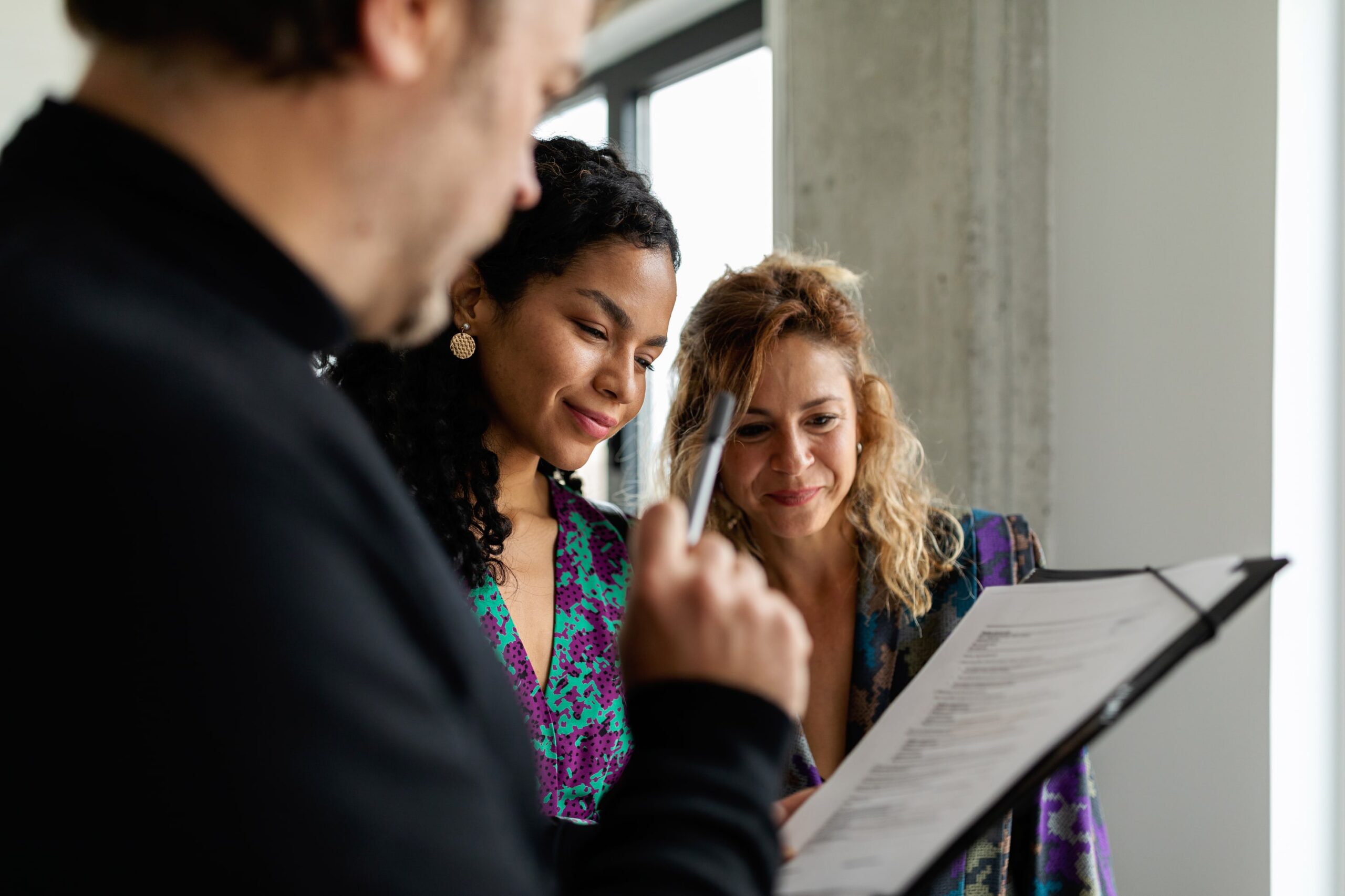 Mixed Race Women looking at paperwork shown by another person