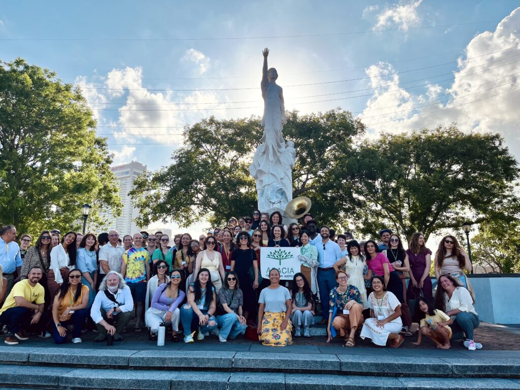 group stands in front of statue in new orleans